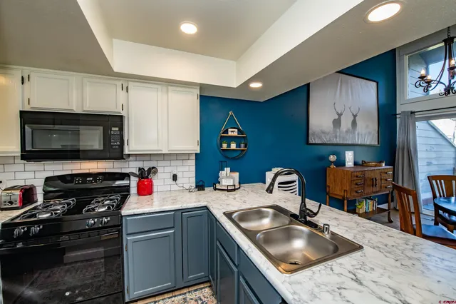 a kitchen with stainless steel appliances granite countertop a sink stove top oven and refrigerator