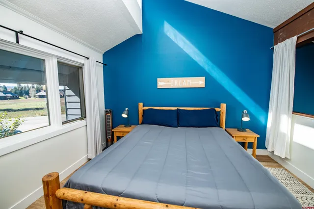 a bedroom with a bed and a large window