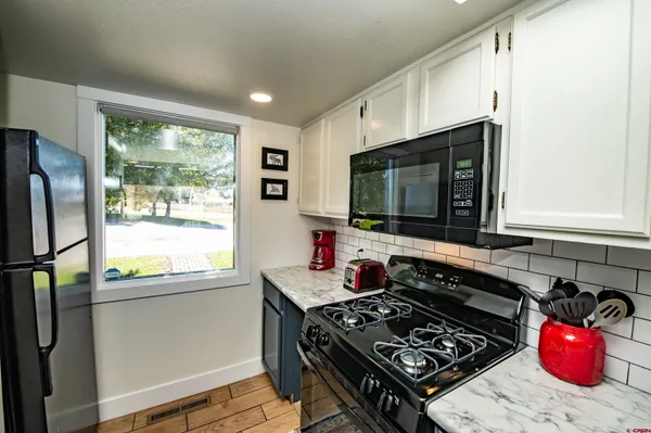 a kitchen with a stove a sink and a microwave