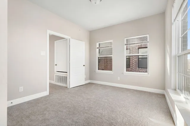 an empty room with windows and closet