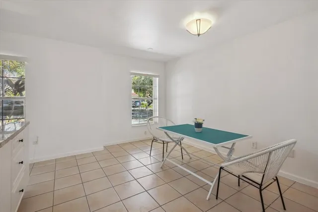a kitchen with white cabinets and window