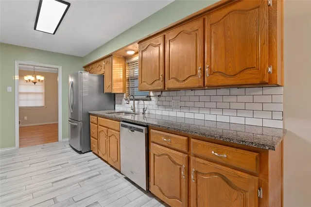 a kitchen with stainless steel appliances granite countertop wooden cabinets a sink and dishwasher