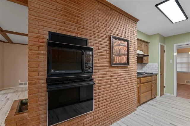 a kitchen that has a stove and cabinets