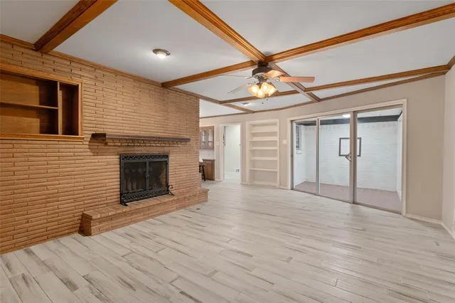 a view of empty room with wooden floor and fireplace