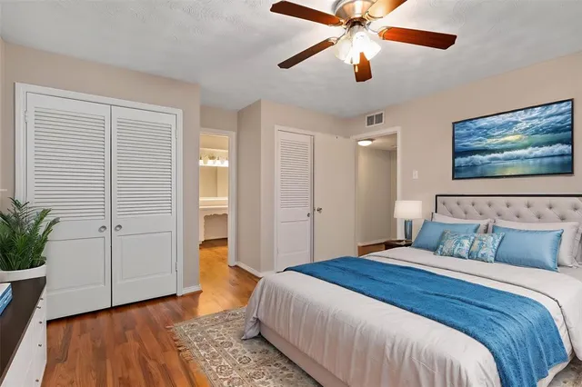 an empty room with wooden floor chandelier fan and closet