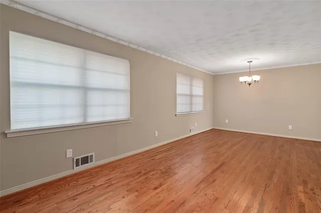 an empty room with wooden floor closet and ceiling fan