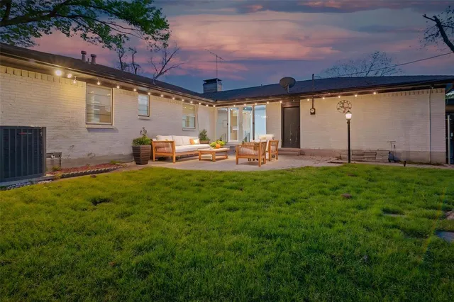 a view of a house with a backyard and a patio