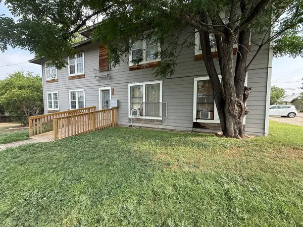 a view of a house with a yard and sitting area