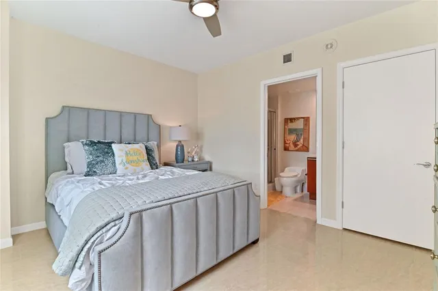 a bed sitting in a bedroom next to a bathroom sink