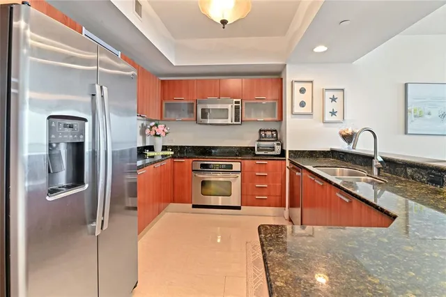 a kitchen with stainless steel appliances granite countertop a stove a sink and a refrigerator