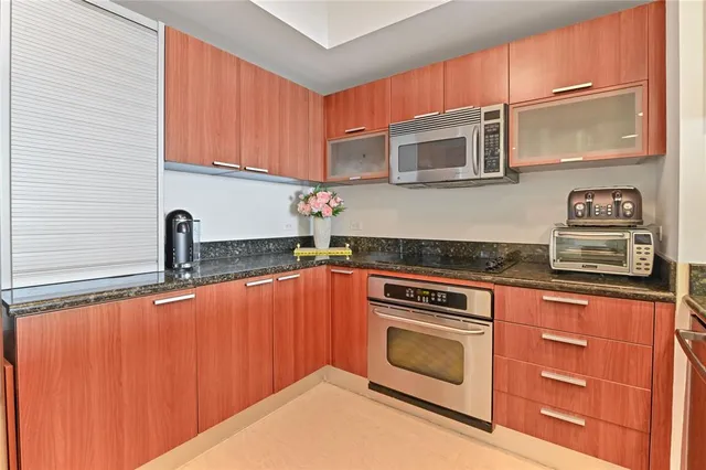 a kitchen with granite countertop cabinets stainless steel appliances and wooden floor