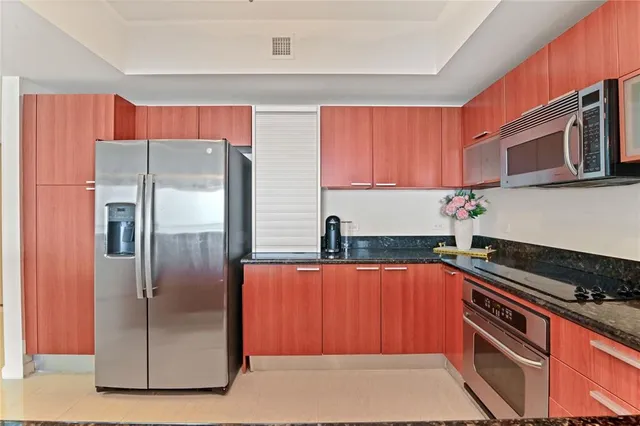 a kitchen with stainless steel appliances granite countertop a refrigerator and a sink