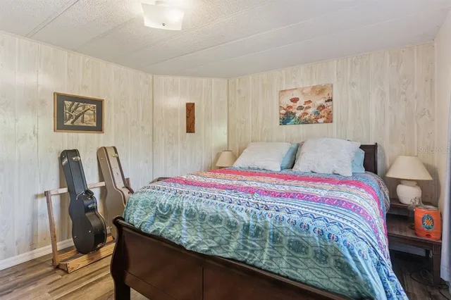 a bedroom with a bed and a painting on the wall