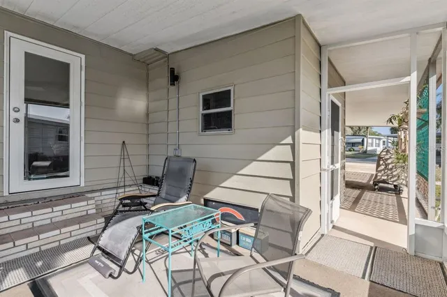 a patio with table and chairs and potted plants