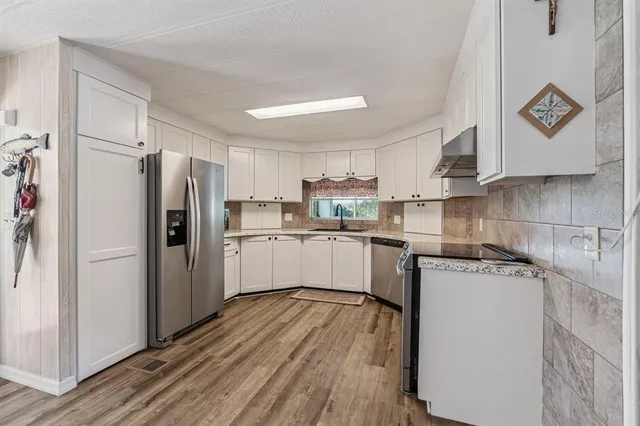 a kitchen with white cabinets and stainless steel appliances