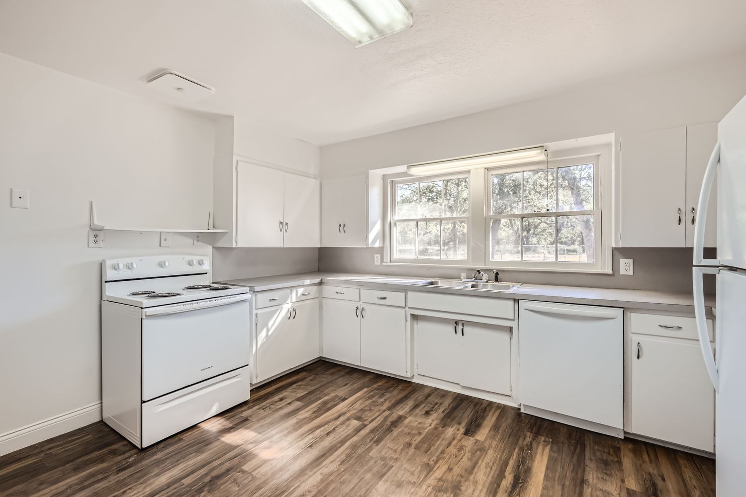 7348 Highway 183 Lockhart, TX 78644 - Photo 8 of 13 Kitchen with white appliances, white cabinets, light countertops, and dark wood-style flooring