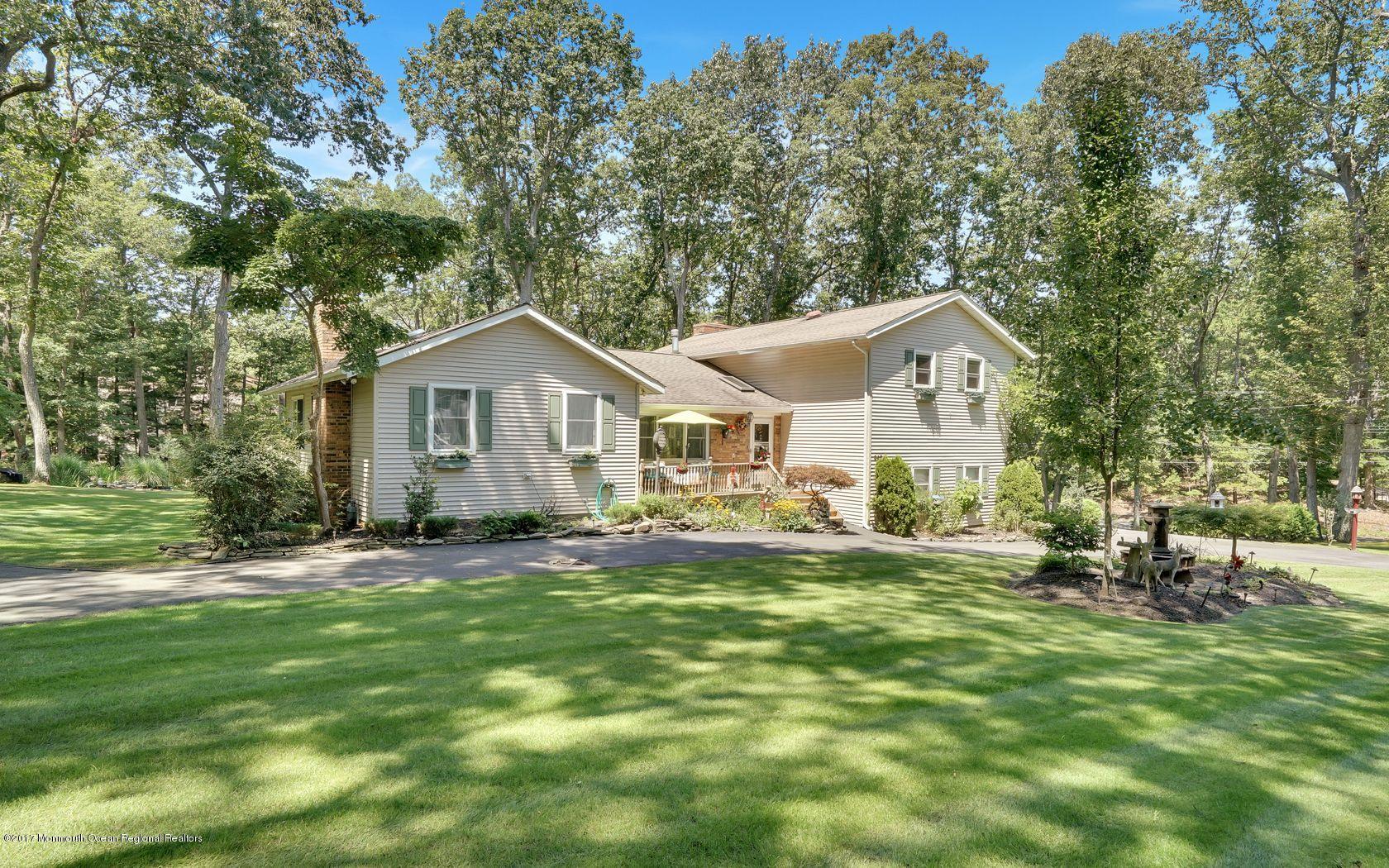 340 Jackson Pines Road Jackson, NJ 08527 - Photo 39 of 41 a front view of a house with a garden and trees