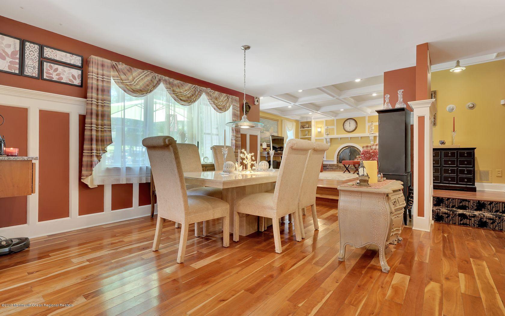 340 Jackson Pines Road Jackson, NJ 08527 - Photo 4 of 41 a dining room with wooden floor a chandelier a glass table and chairs