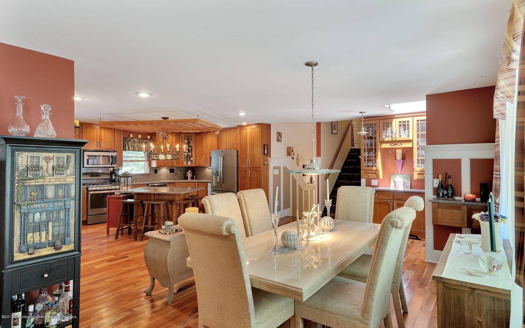 340 Jackson Pines Road Jackson, NJ 08527 - Photo 5 of 41 a view of a dining room and livingroom with furniture wooden floor a rug a fireplace and a view