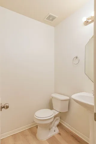 a white toilet sitting next to a white sink and vanity