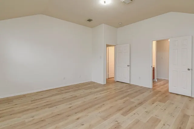 a view of an empty room and wooden floor