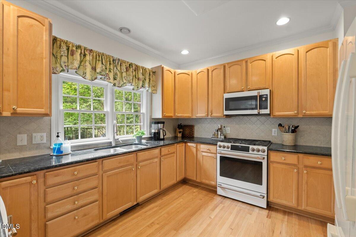 109 Hemingway Forest Place Raleigh, NC 27607 - Photo 13 of 33 a kitchen with stainless steel appliances granite countertop white cabinets granite counter tops and a window