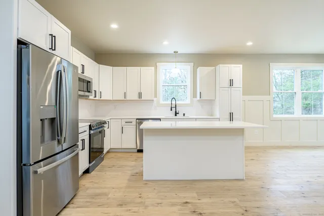 a kitchen with stainless steel appliances a refrigerator sink and cabinets