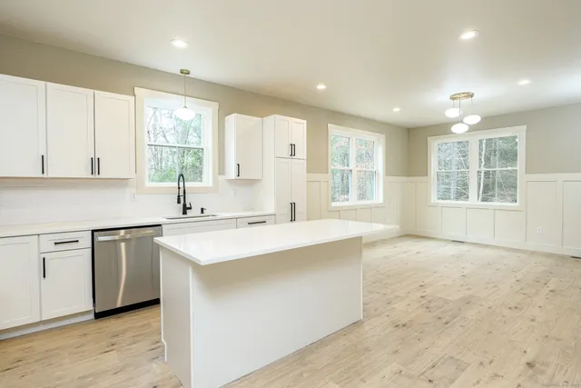 a kitchen with stainless steel appliances granite countertop a sink stove and cabinets