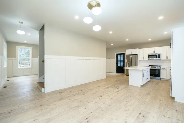 a view of a kitchen with furniture and stainless steel appliances