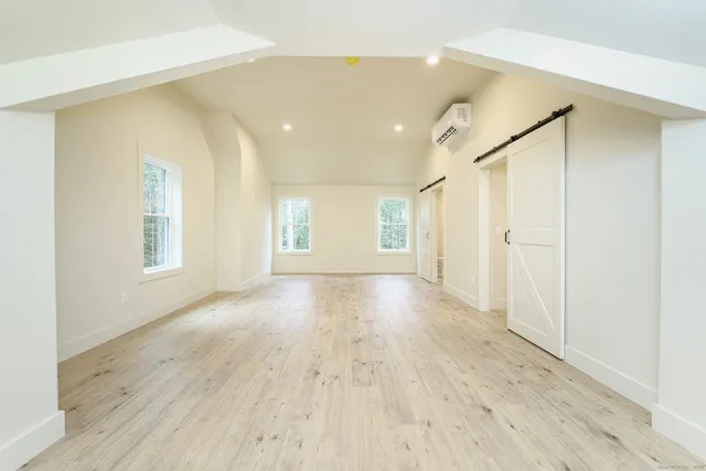 a view of a big room with wooden floor and windows