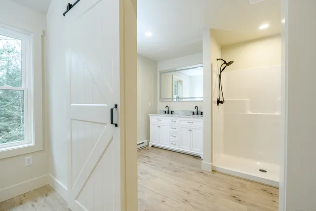 a bathroom with a granite countertop sink a mirror and a shower