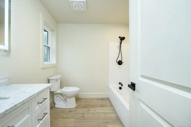 a bathroom with a sink a toilet and shower