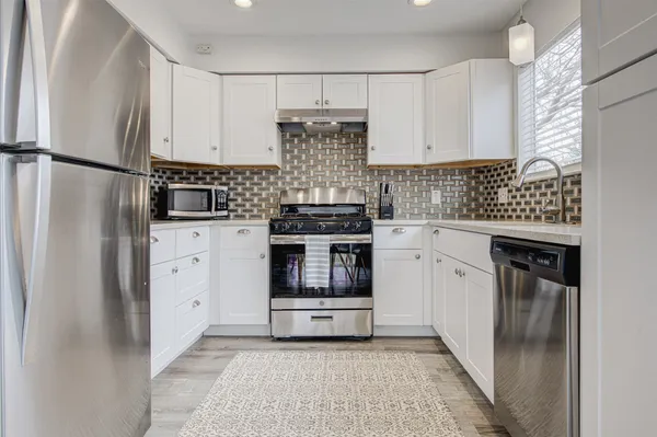 a kitchen with a stove top oven and refrigerator