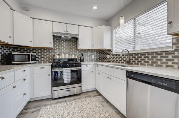 a kitchen with granite countertop white cabinets and white appliances