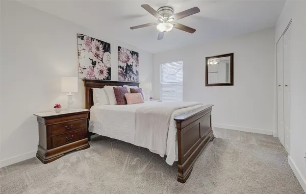 a spacious bedroom with a bed and a chandelier