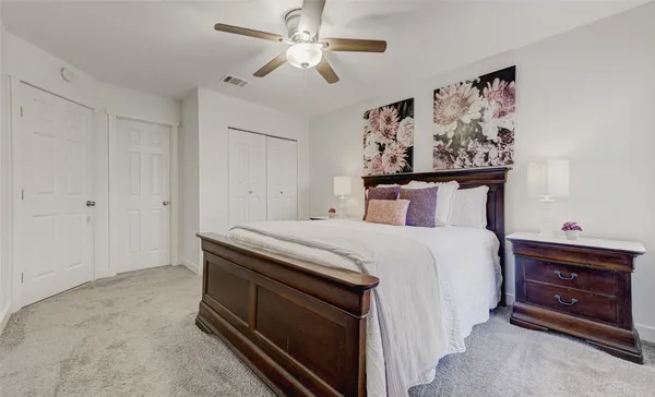 a bedroom with a bed and a painting on the wall