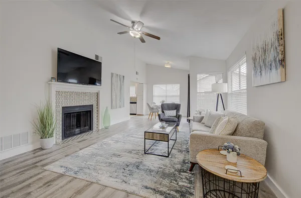 a living room with furniture a flat screen tv and a fireplace