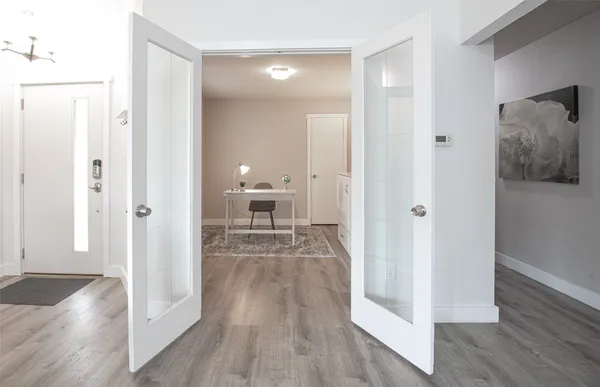a view of a hallway with wooden floor windows and livingroom
