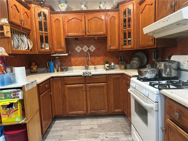 a kitchen with stainless steel appliances a sink a stove a refrigerator and cabinets