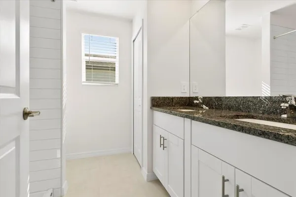 a bathroom with a granite countertop sink and a mirror
