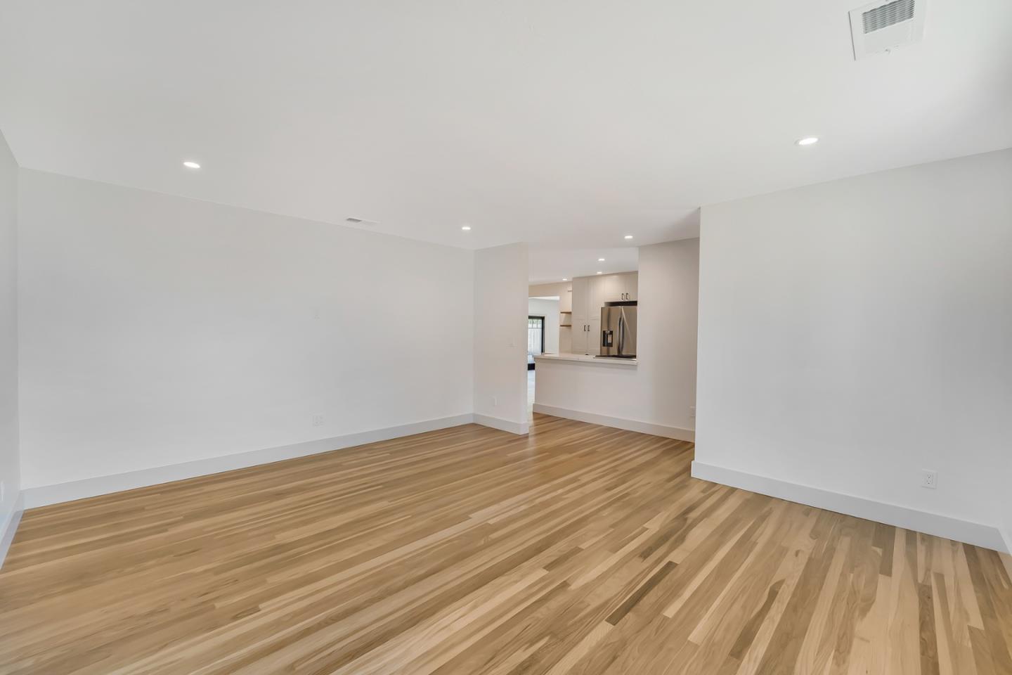890 Quintinia Drive Sunnyvale, CA 94086 - Photo 13 of 37 a view of empty room with wooden floor and kitchen