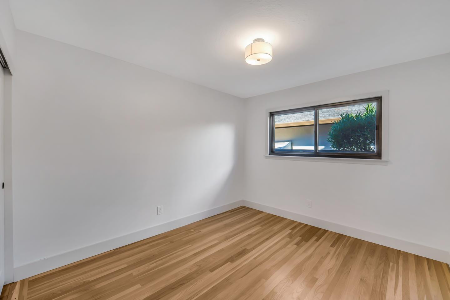 890 Quintinia Drive Sunnyvale, CA 94086 - Photo 19 of 37 a view of empty room with wooden floor and fan