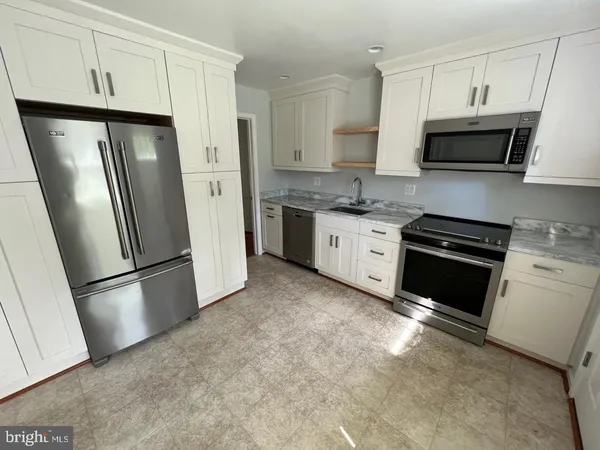 a kitchen with stainless steel appliances a refrigerator sink and microwave