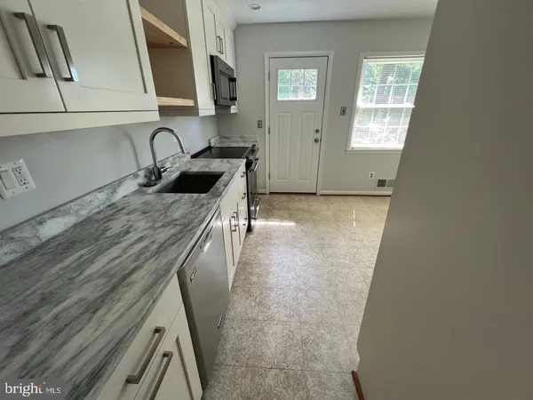 a kitchen with a sink a stove and cabinets