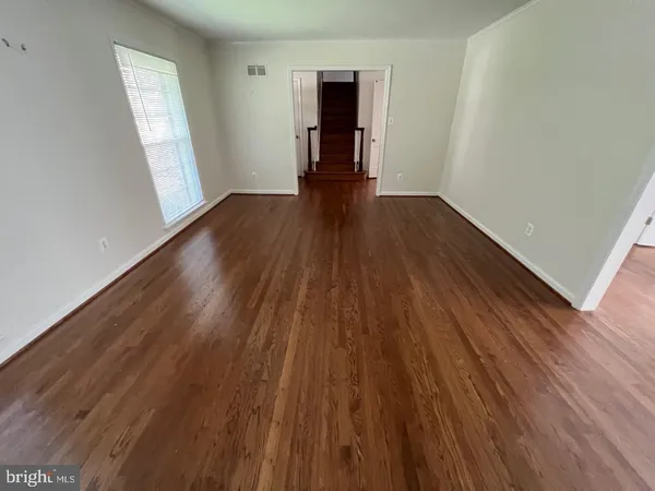 wooden floor in an empty room with a window