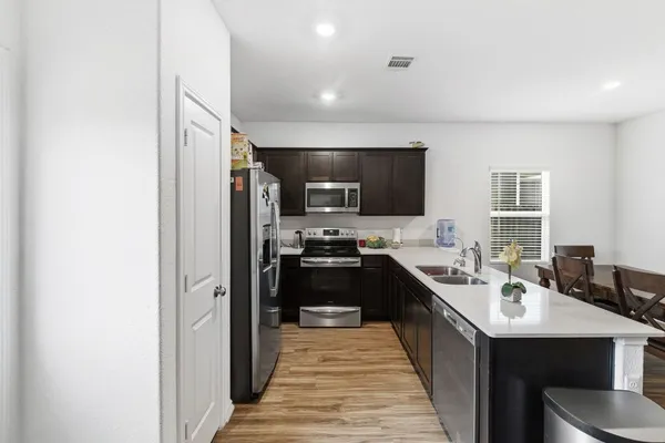 a kitchen with stainless steel appliances a sink stove and refrigerator