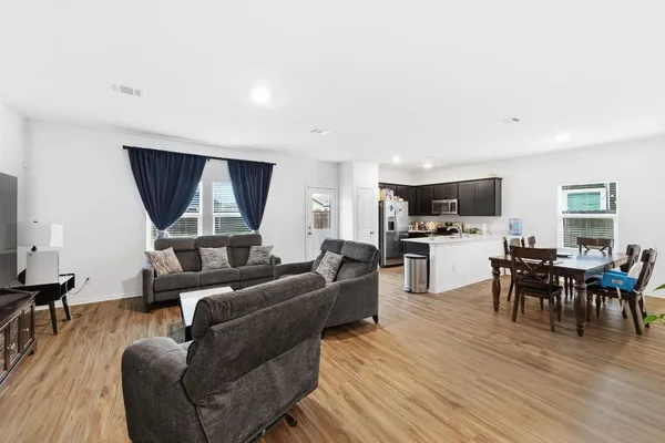 a living room with furniture and a wooden floor