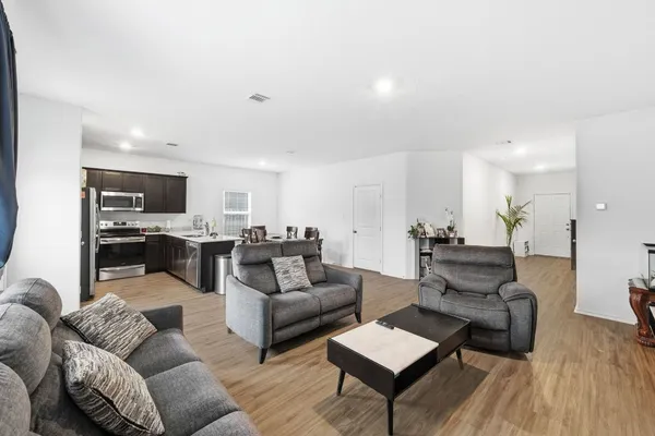 a living room with furniture and view of kitchen