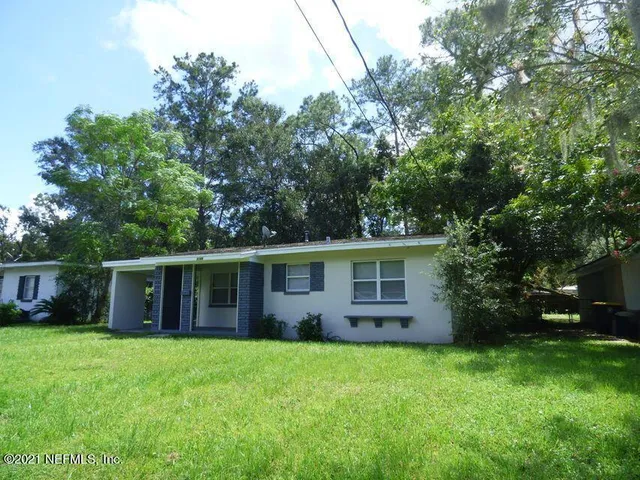 a view of a house with backyard and garden