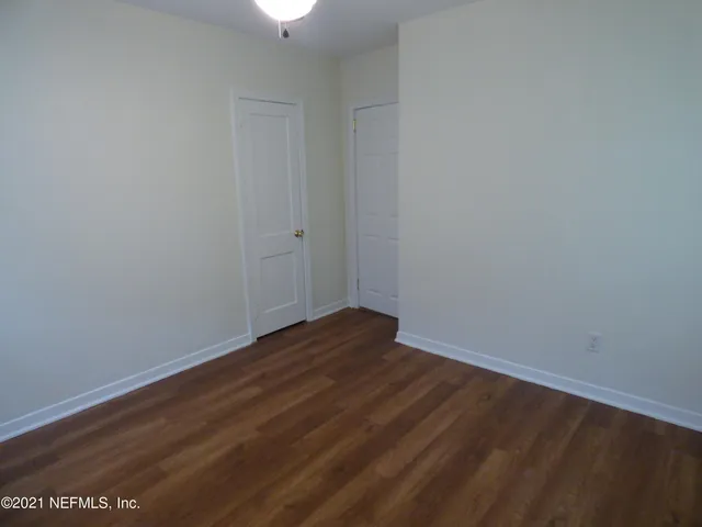 a view of an empty room with wooden floor